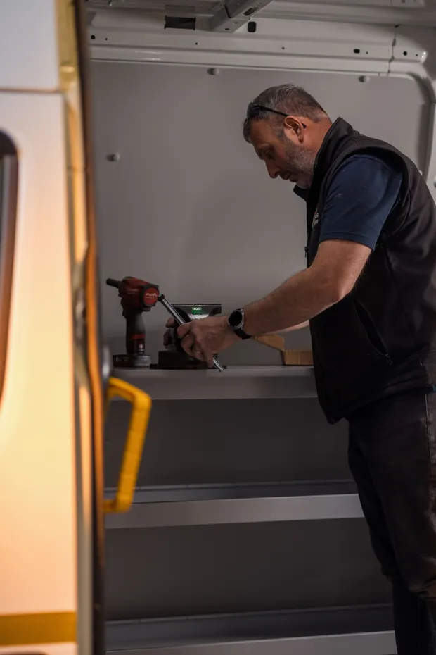 Technician fitting out a welfare van interior