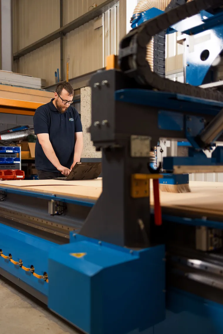 Dack technician operating the CNC router in the Lincoln workshop