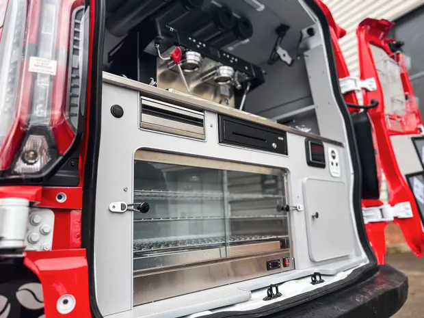 Rear serving bay of the Cafe2U van with espresso machine, heated cabinet and till